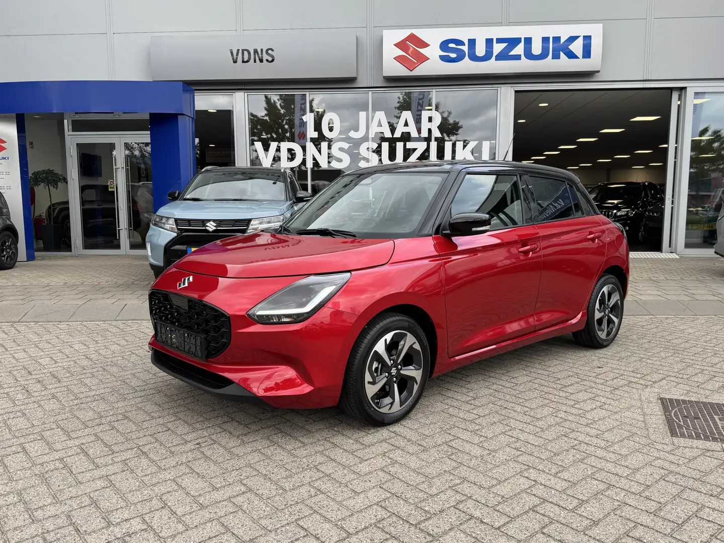 Suzuki Swift 1.2 Style Smart Hybrid info: M.Safari Rood - 1