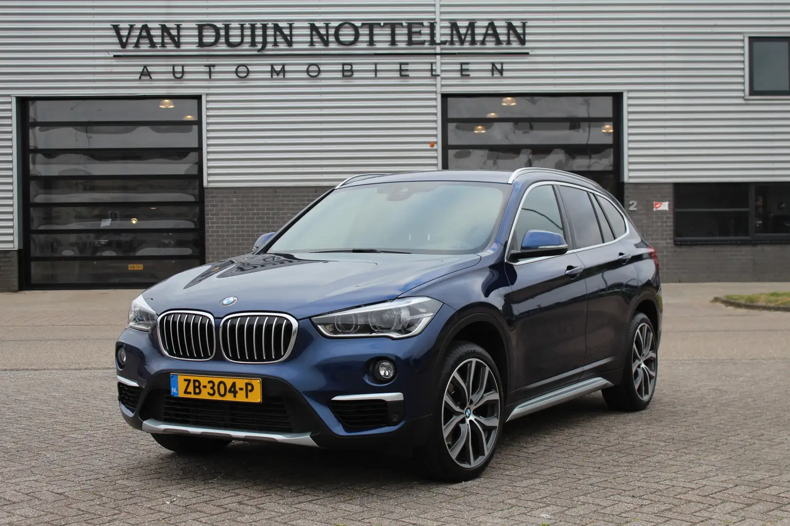 BMW X1 xDrive20i High Executive / HUD / Leer / Camera / N Blau - 1