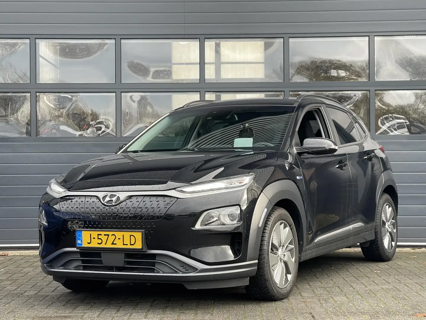 Hyundai KONA EV FASHION 64 KWH I 3 FASE I 100% SOH I P-CAMERA I Zwart - 1