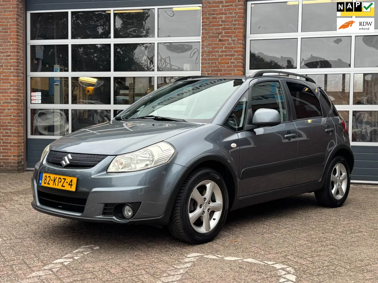 Suzuki SX4 1.6 Shogun, Airco, PDC, 1e Eig. NL auto Gris - 1