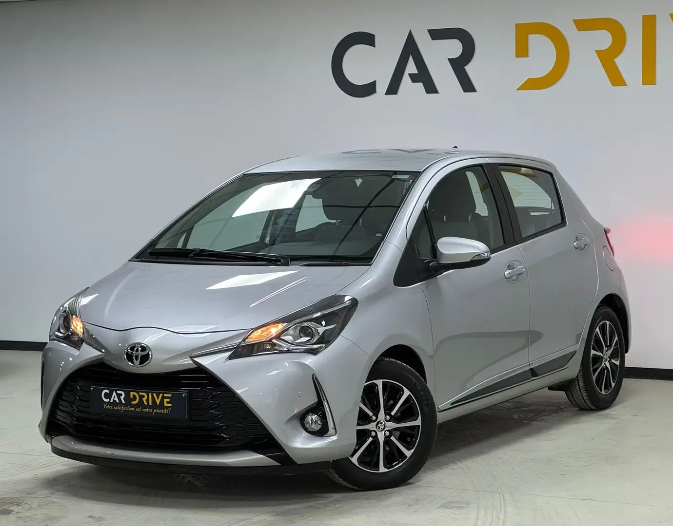 Toyota Yaris 1.5i B AUTO/CAMERA/CAPTEURS/CRUISE ADAPT/1ER PROP Argent - 1