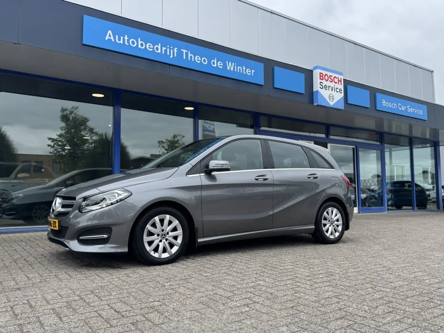 Mercedes-Benz B 180 Prestige| Trekhaak, Navi, Cruise, Stoelverwarming, Grijs - 1