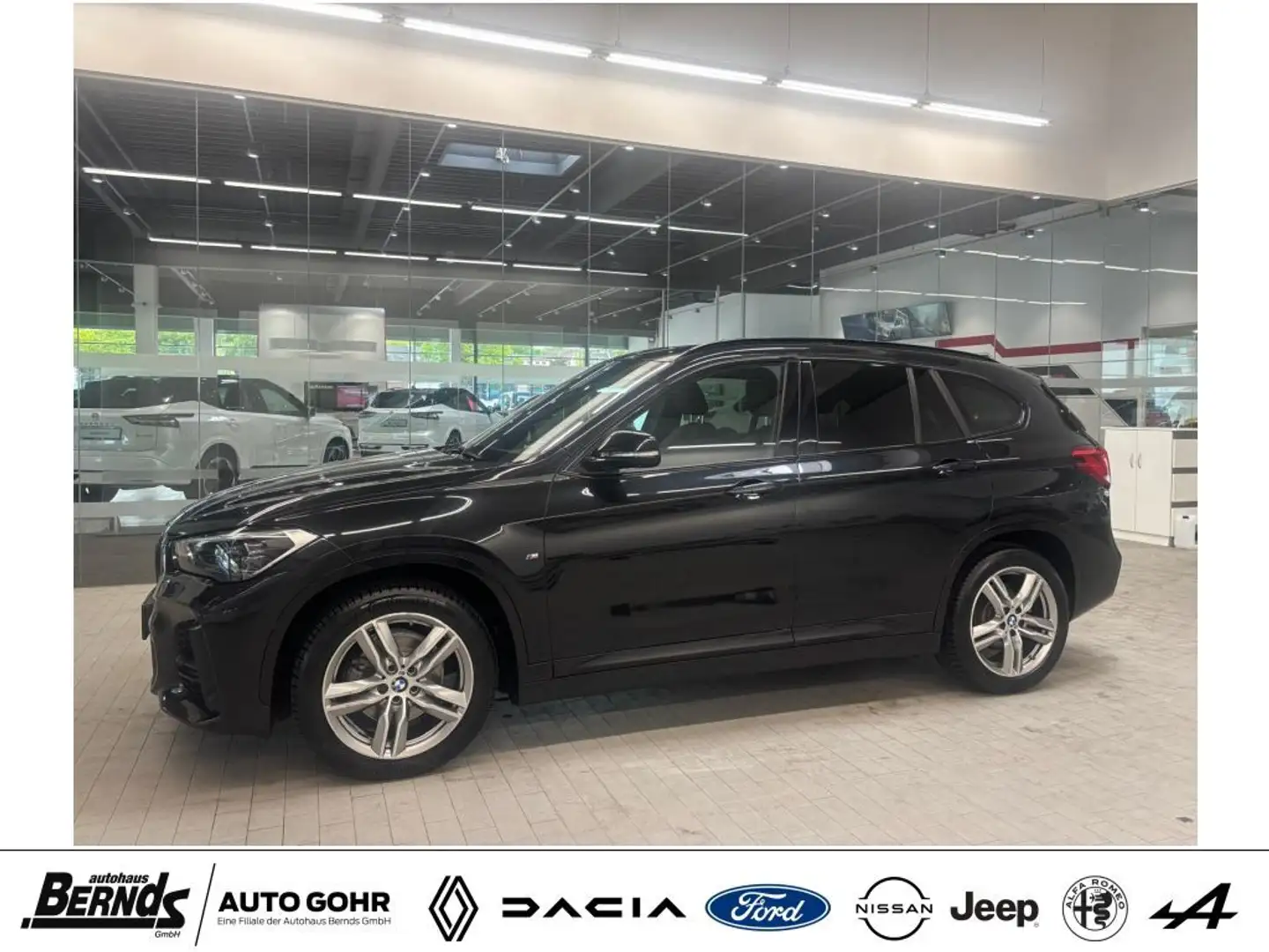BMW X1 sDrive18i Aut. M Sport - AHK abn., Navi, SHZ, PDC Zwart - 1
