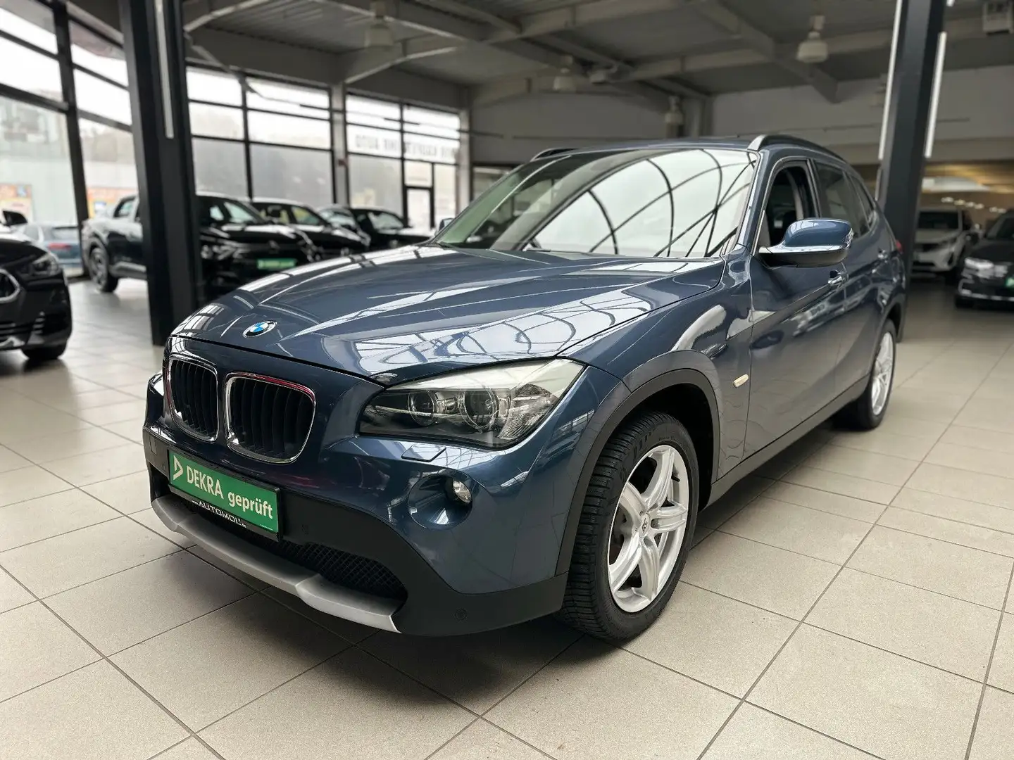 BMW X1 18 i sDrive Tuner*SHZ*AHK*PDC*Allwetter* Blauw - 1