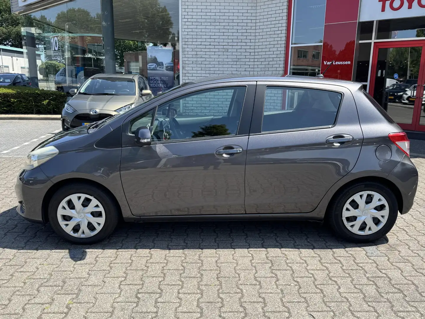Toyota Yaris 1.3 VVT-i ASPIRATION NL-AUTO 1E-EIG DEALER-OND NAV Grijs - 2