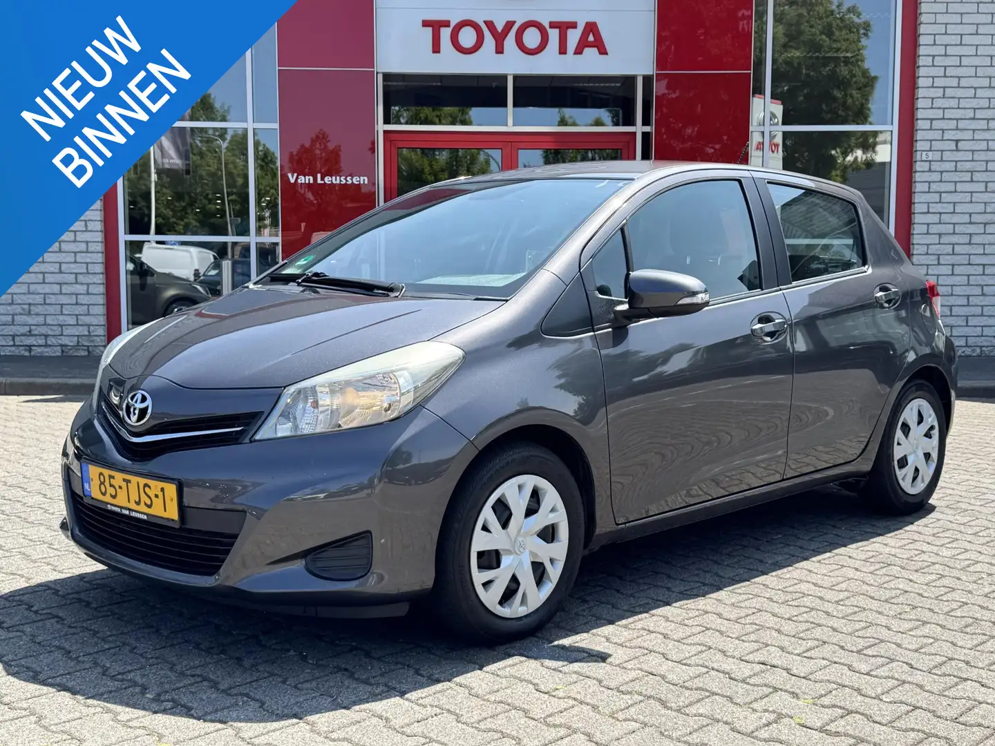 Toyota Yaris 1.3 VVT-i ASPIRATION NL-AUTO 1E-EIG DEALER-OND NAV Grijs - 1