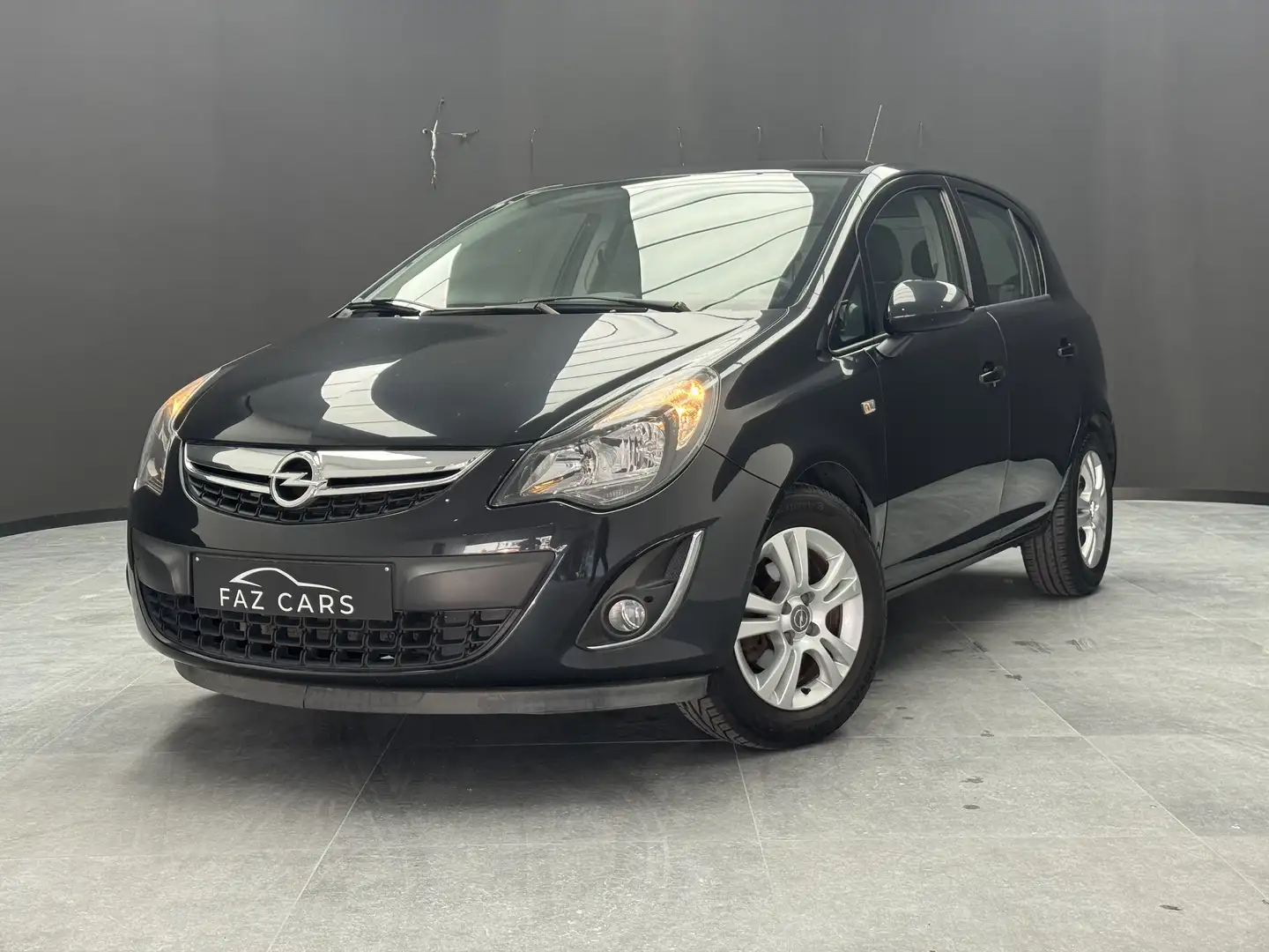 Opel Corsa 1.2i Enjoy * 1ER PROP + CLIM + JANTES + GARANTIE * Zwart - 1