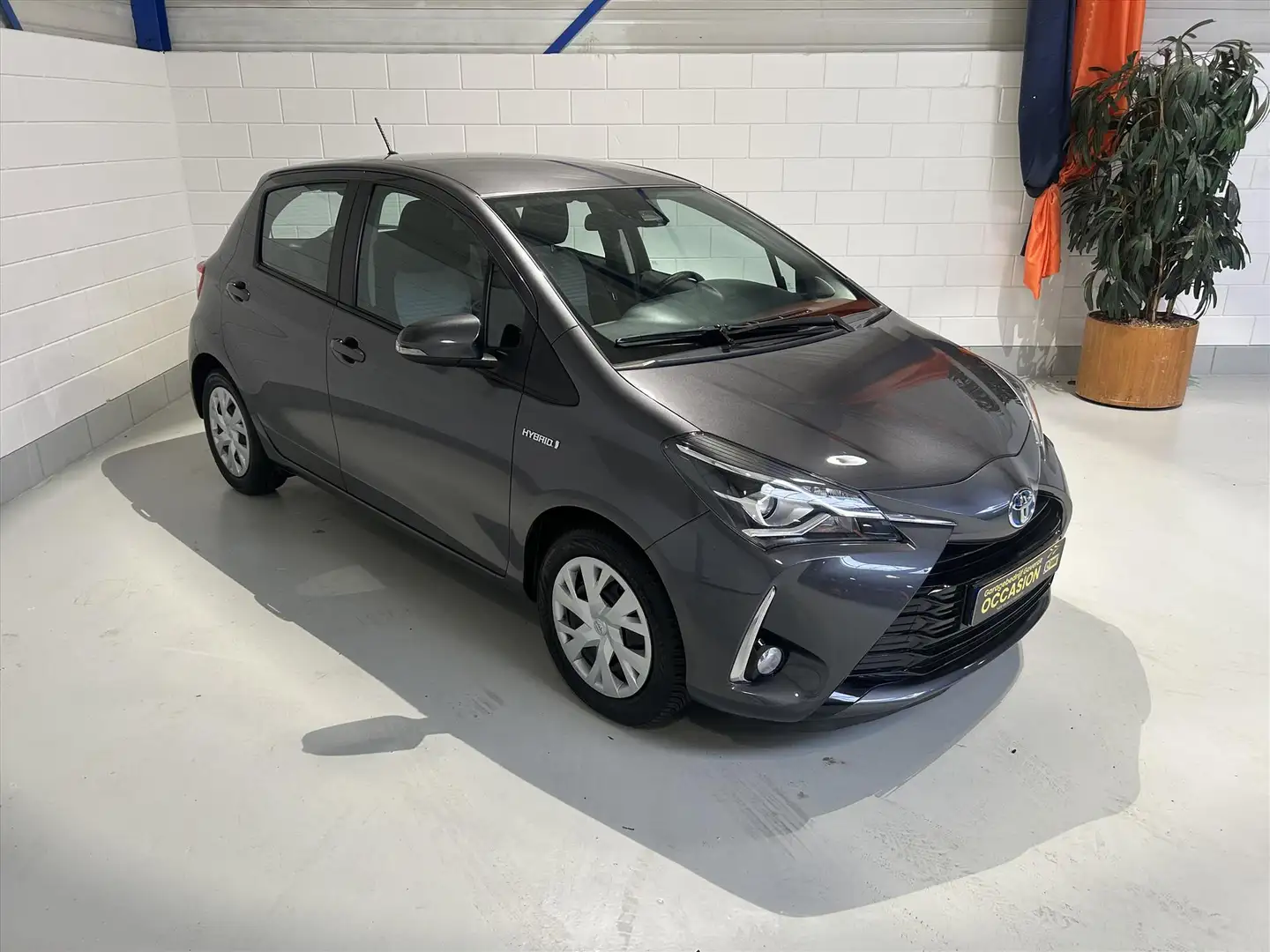 Toyota Yaris 1.5 Hybrid 100pk 5D CVT 59dkm, Cruise, Clima, Navi Gris - 1