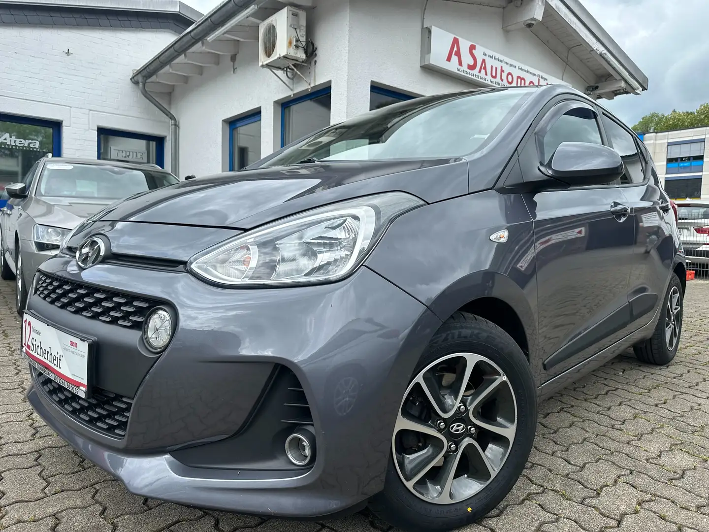 Hyundai i10 1.2+NAVI+KLIMA+PDC+SHZ+TEMPOMAT+1.HAND+5 TÜRE Grijs - 1