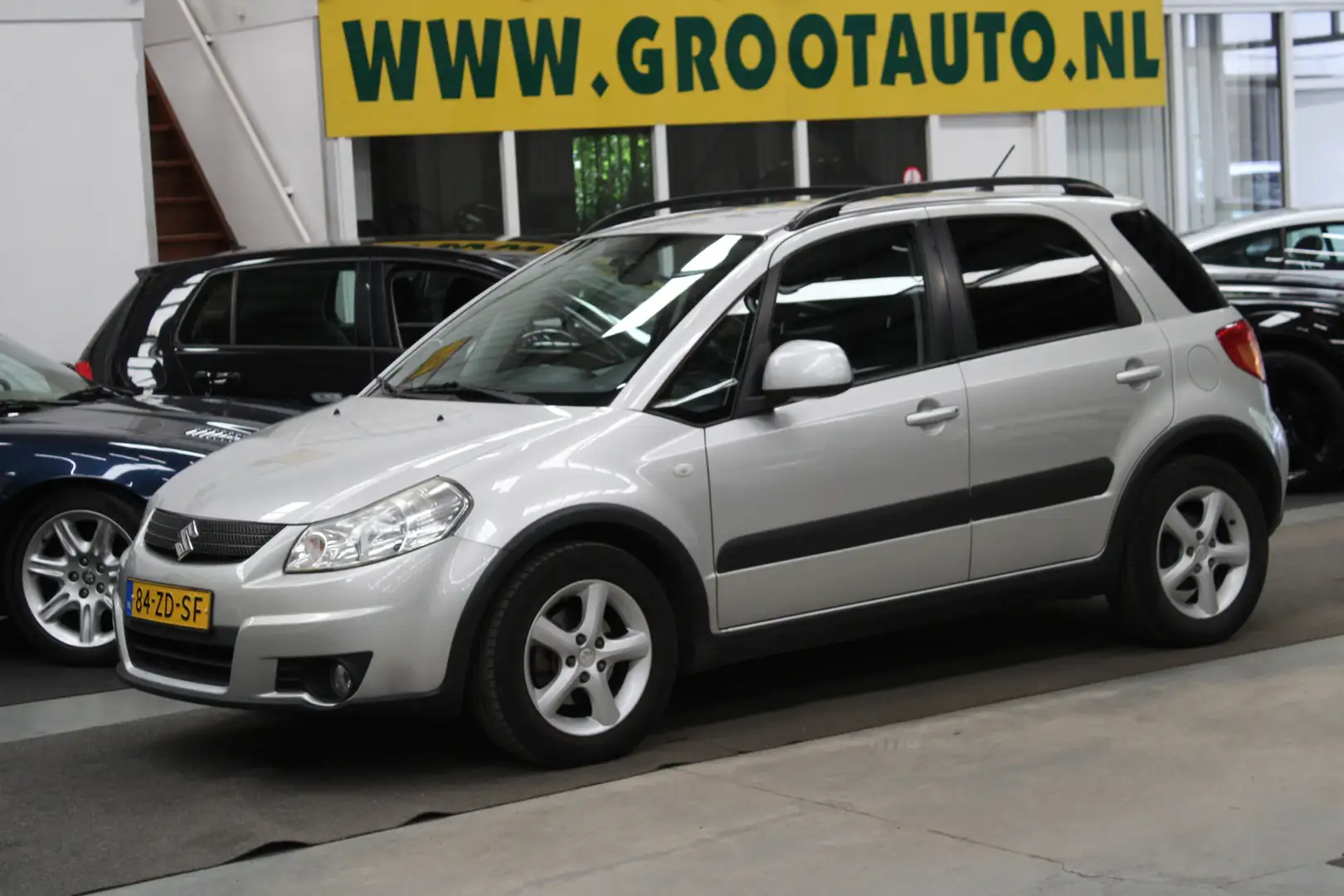 Suzuki SX4 1.6 Shogun NAP, Airco, Cruise control, Trekhaak, S Gris - 1